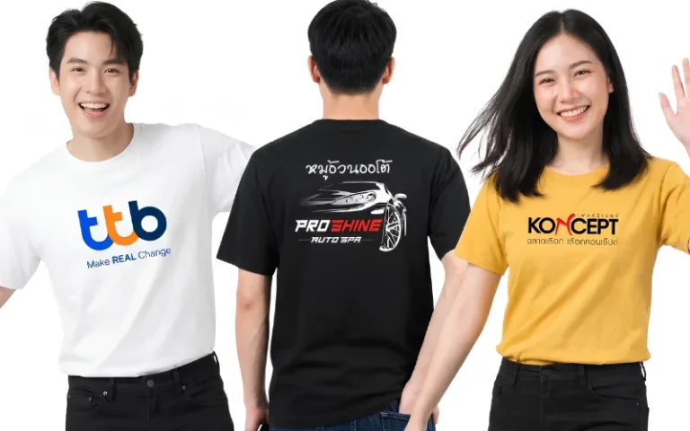 ตัวอย่างงานรับสกรีนเสื้อยืดให้กับลูกค้าที่ผ่านมา แสดงแบบจำลองชายหญิง 3 คน ยืนยิ้มแย้มและโพสท่าอย่างมั่นใจบนพื้นหลังสีขาวล้วน คนซ้ายสุดเป็นนายแบบสวมเสื้อยืดคอกลมสีขาว ตรงกลางอกสกรีนโลโก้ธนาคารทีทีบีตัวอักษร 'ttb' สีน้ำเงินส้ม พร้อมข้อความภาษาอังกฤษด้านล่างว่า 'Make REAL Change' คนกลางเป็นนายแบบหันหลังสวมเสื้อยืดคอกลมสีดำ โชว์งานสกรีนกลางหลังลายกราฟิกรถสปอร์ตหรูสีขาวคู่กับข้อความว่า 'หมูอ้วนออโต้ PRO SHINE AUTO SPA' และคนขวาสุดเป็นนางแบบสวมเสื้อยืดคอกลมสีเหลืองมัสตาร์ด กำลังโบกมือยิ้มแย้ม ตรงกลางอกสกรีนโลโก้แบรนด์เฟอร์นิเจอร์ คอนเซ็ปต์ 'KONCEPT เฟอร์นิเจอร์ ฉลาดเลือก เลือกคอนเซ็ปต์' ตัวอักษรสีดำแดง