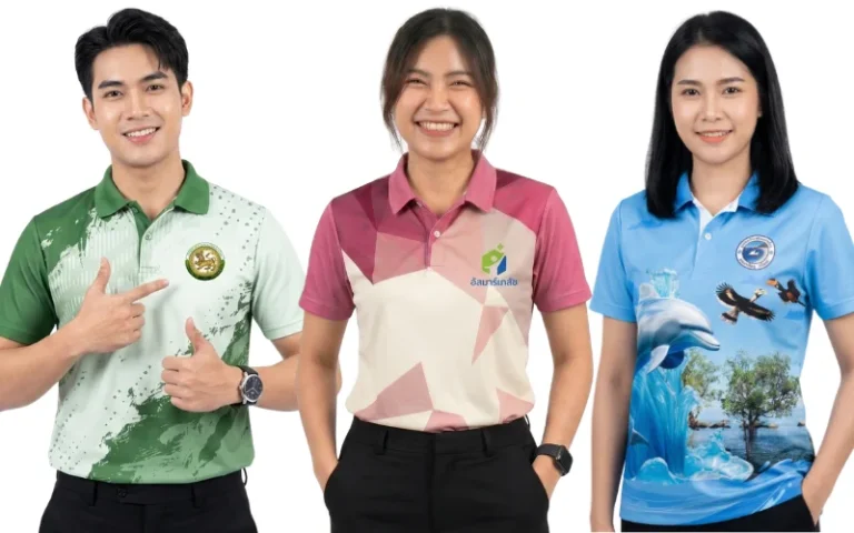 ตัวอย่างผลงานจากโรงงานรับผลิตเสื้อพิมพ์ลาย แสดงแบบเสื้อคอโปโลและเสื้อทีมพิมพ์ลาย 3 ดีไซน์ ด้านซ้ายเป็นผู้ชายสวมเสื้อโปโลสีเขียวเข้มสลับเขียวอ่อนพิมพ์ลายกราฟิกสาดสีพร้อมตราสัญลักษณ์หน่วยงาน ตรงกลางเป็นผู้หญิงสวมเสื้อโปโลสีชมพูกะปิตัดครีมพิมพ์ลายกราฟิกเรขาคณิตสามเหลี่ยมเฉดสีสุภาพสกรีนอัส มาร์เก็ต และด้านขวาเป็นผู้หญิงสวมเสื้อโปโลสีฟ้าสดใสพิมพ์ลายภาพวาดธรรมชาติ โลมา นกเงือก และป่าชายเลน ทุกตัวผลิตด้วยเทคนิคพิมพ์ซับลิเมชันสีสดคมชัด
